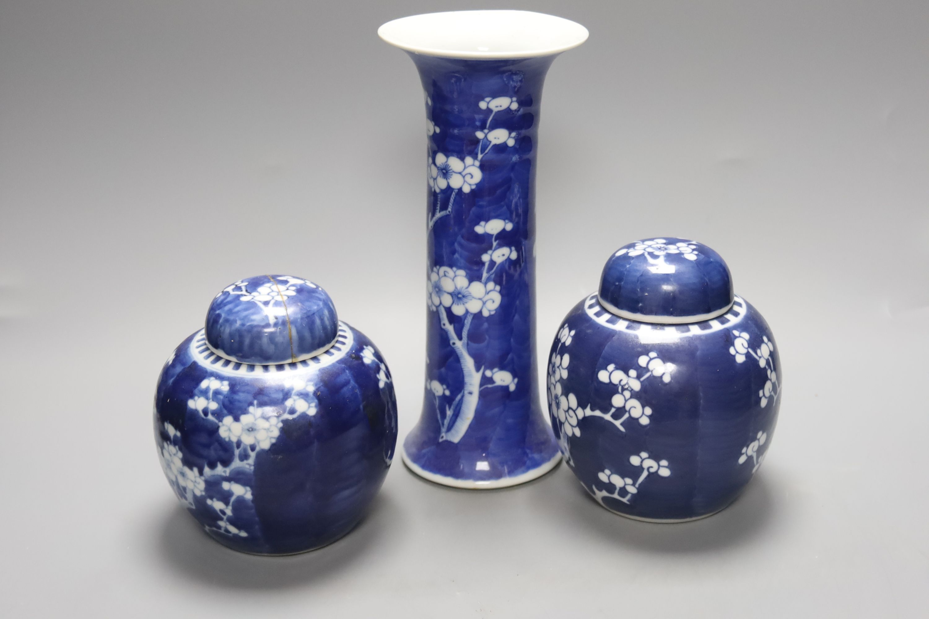 Two Chinese blue and white prunus pattern ginger jars and a similar cylinder vase, tallest 26cm